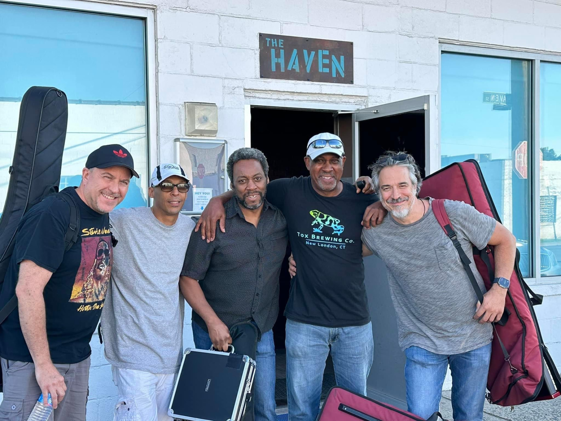 Andre and his full band with their instruments outside The Haven